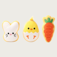 Load image into Gallery viewer, Three simple, plush dog toys shaped like Easter-themed sugar cookies. The bunny has a white face with simple, cute face. The chick looks like it's hatching from an egg, with its "cracked egg" bottom half and chick body top half. It has a cute, simple face. The carrot has an orange body with green leaf top.
