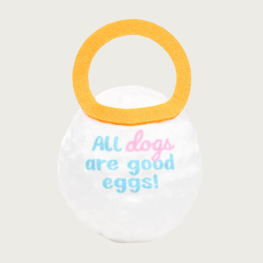 Back of the Good Egg toy. It has pale pink and blue text in the center that reads "All dogs are good eggs!"