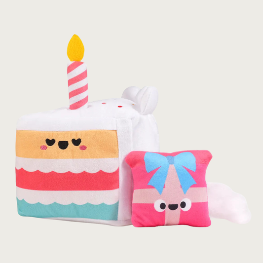Additional view of the cake slice dog toy, with the small, plush gift box that will be found inside, once the dog tears the cake open. The gift box is pink with pink & blue ribbon and a smiley face.
