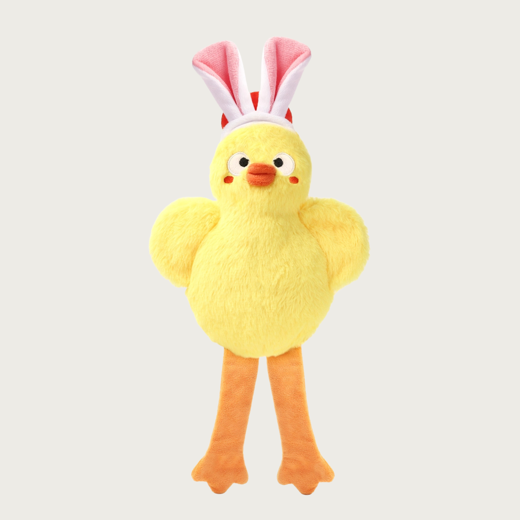 Yellow plush dog toy that resembles a chick wearing bunny ears. It has long orange legs.