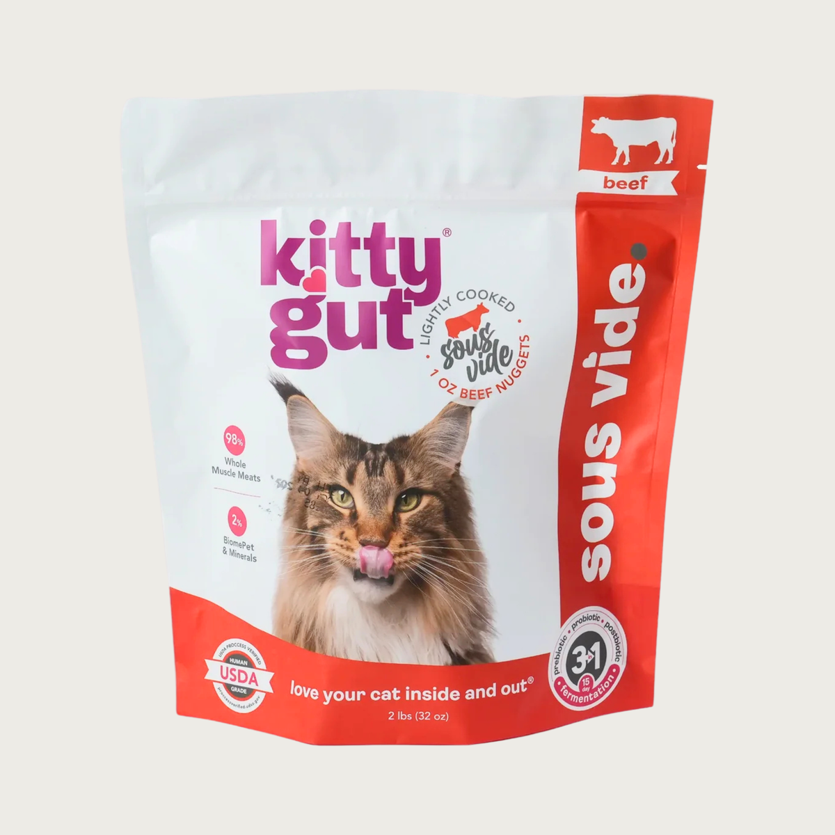A 2 lb bag of Kitty Gut sous vide lightly cooked beef cat food, featuring a white and red stand-up, resealable bag with a picture of a Maine Coon cat on the front. 1 oz nuggets.