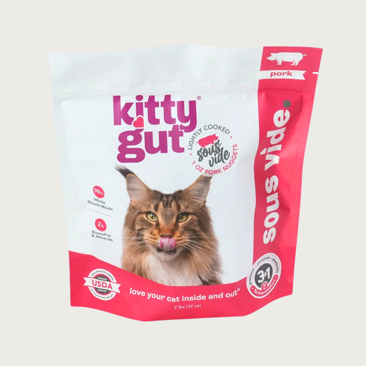 A 2 lb bag of Kitty Gut sous vide lightly cooked pork cat food, featuring a white and hot pink stand-up, resealable bag with a picture of a Maine Coon cat on the front. 1 oz nuggets.