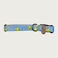 Load image into Gallery viewer, 0.75 in width, dog collar with bouncing lime green tennis balls on a light denim blue background with stainless d-ring and black plastic buckle.
