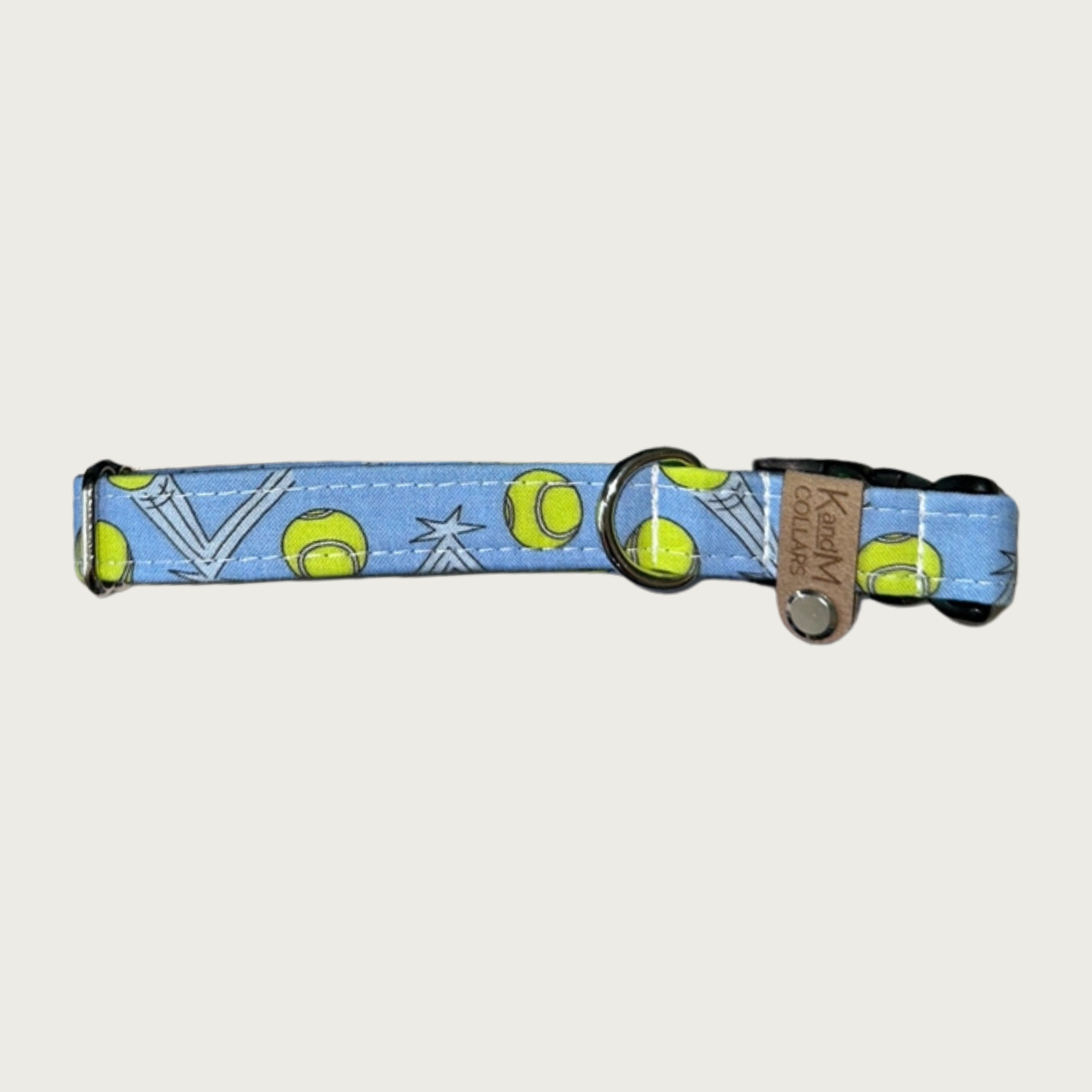 0.75 in width, dog collar with bouncing lime green tennis balls on a light denim blue background with stainless d-ring and black plastic buckle.
