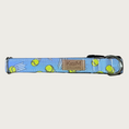 Load image into Gallery viewer, 1in width, dog collar with bouncing lime green tennis balls on a light denim blue background with stainless d-ring and black plastic buckle.
