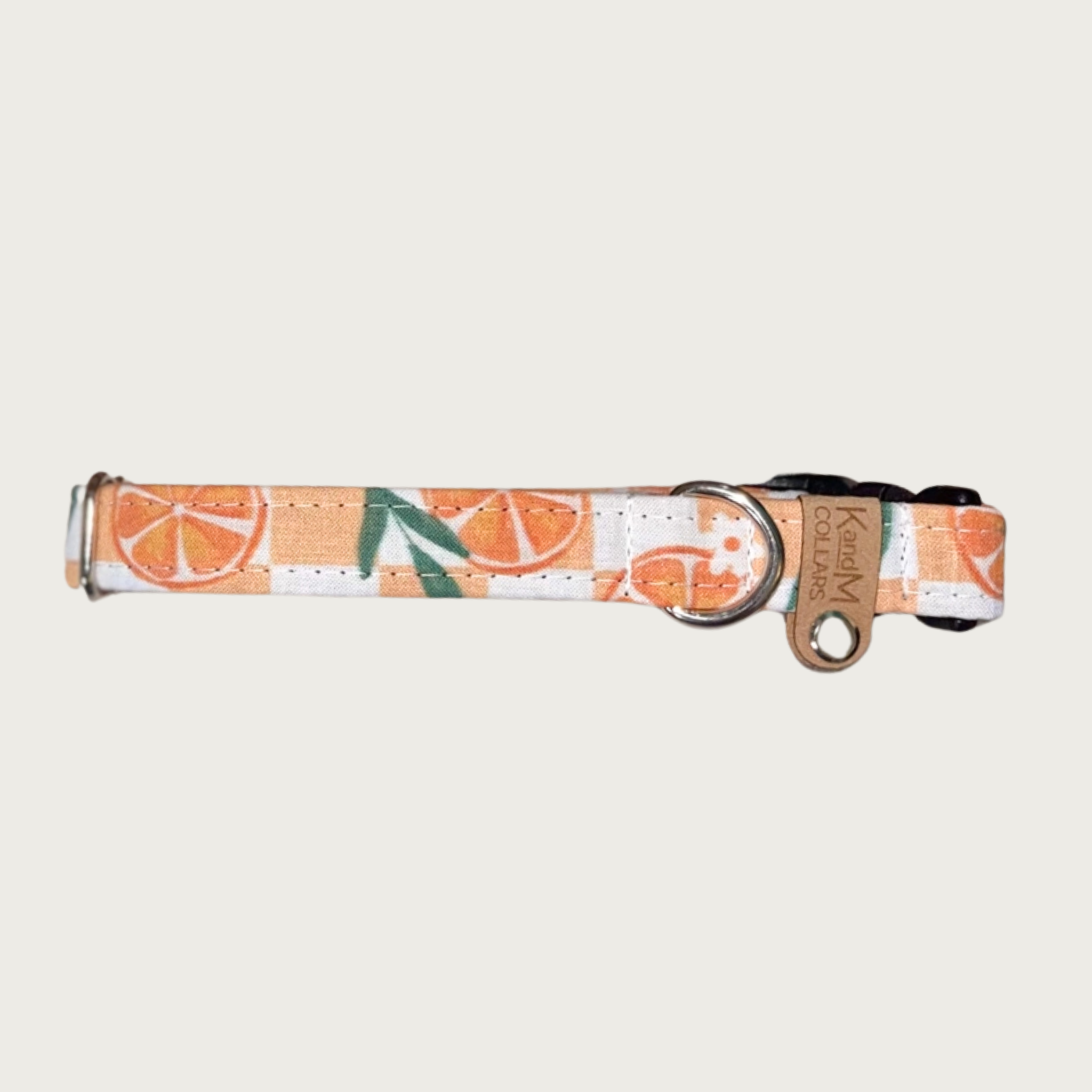 0.75" width dog collar with round orange slices and white flowers & greenery, on a pale orange & white checkered background. 