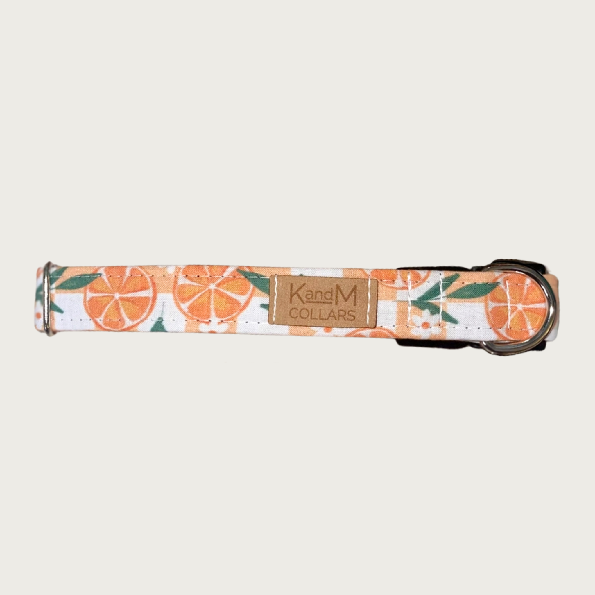 1" width dog collar with round orange slices and white flowers & greenery, on a pale orange & white checkered background. 