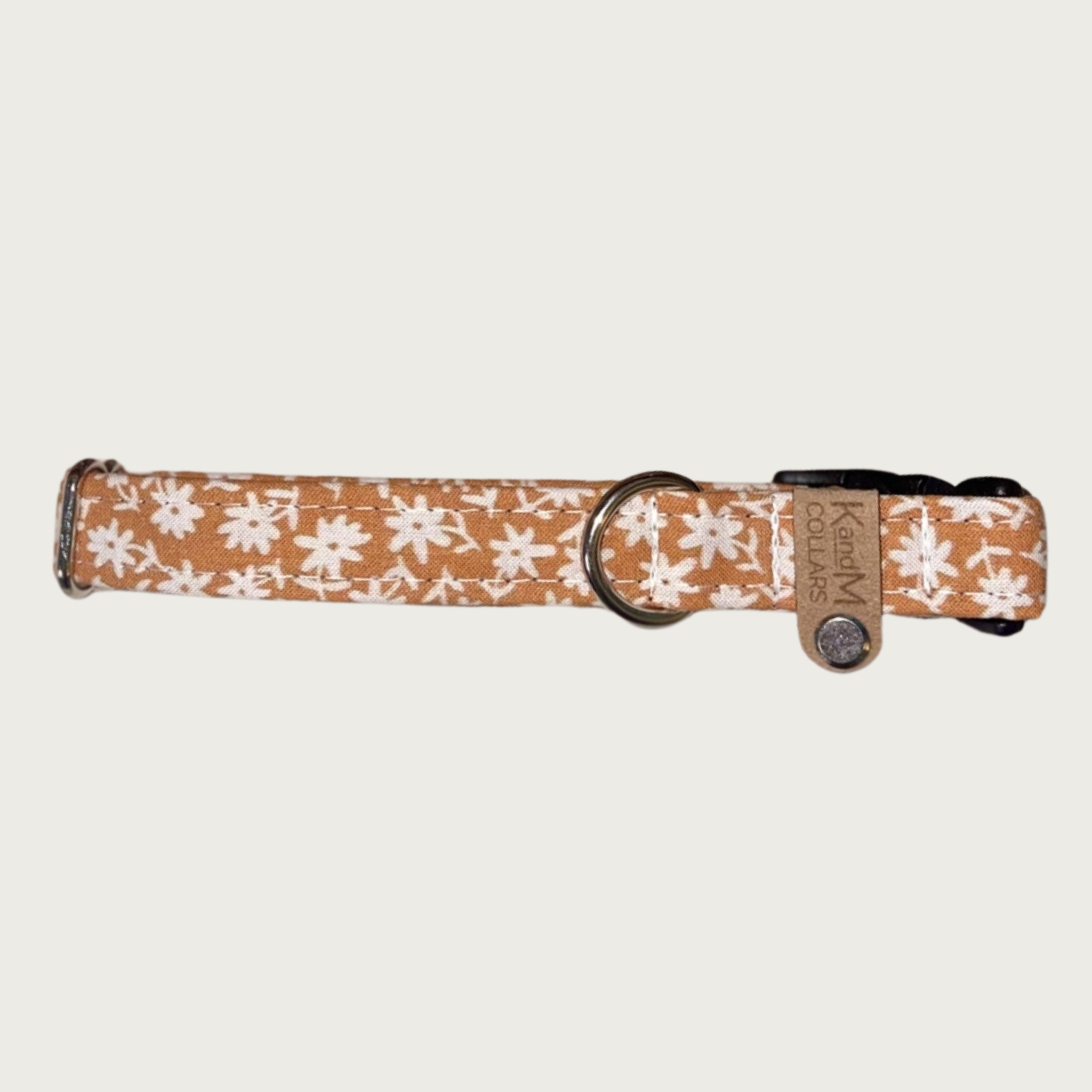 0.75" width dog collar, featuring a tiny floral print in cream, on a light brownish-orange background.