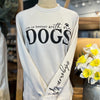 An off-white, crew neck sweatshirt. Black text on chest reads, "Life is better with my dogs." The words "with my" are in cursive writing, and the word "dogs" is in extra large print, all caps. There is a paw print icon over the word "my". On the left sleeve, there is text that reads from the elbow down to the wrist, "#dogmomlife"