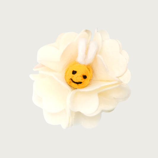 Felted wool dog collar flower, shaped like a cream hydrangea flower, with a smiling yellow bee with wings in the center.