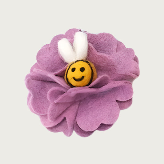 Felted wool dog collar flower, shaped like a lilac colored hydrangea flower, with a smiling yellow bee with wings in the center.