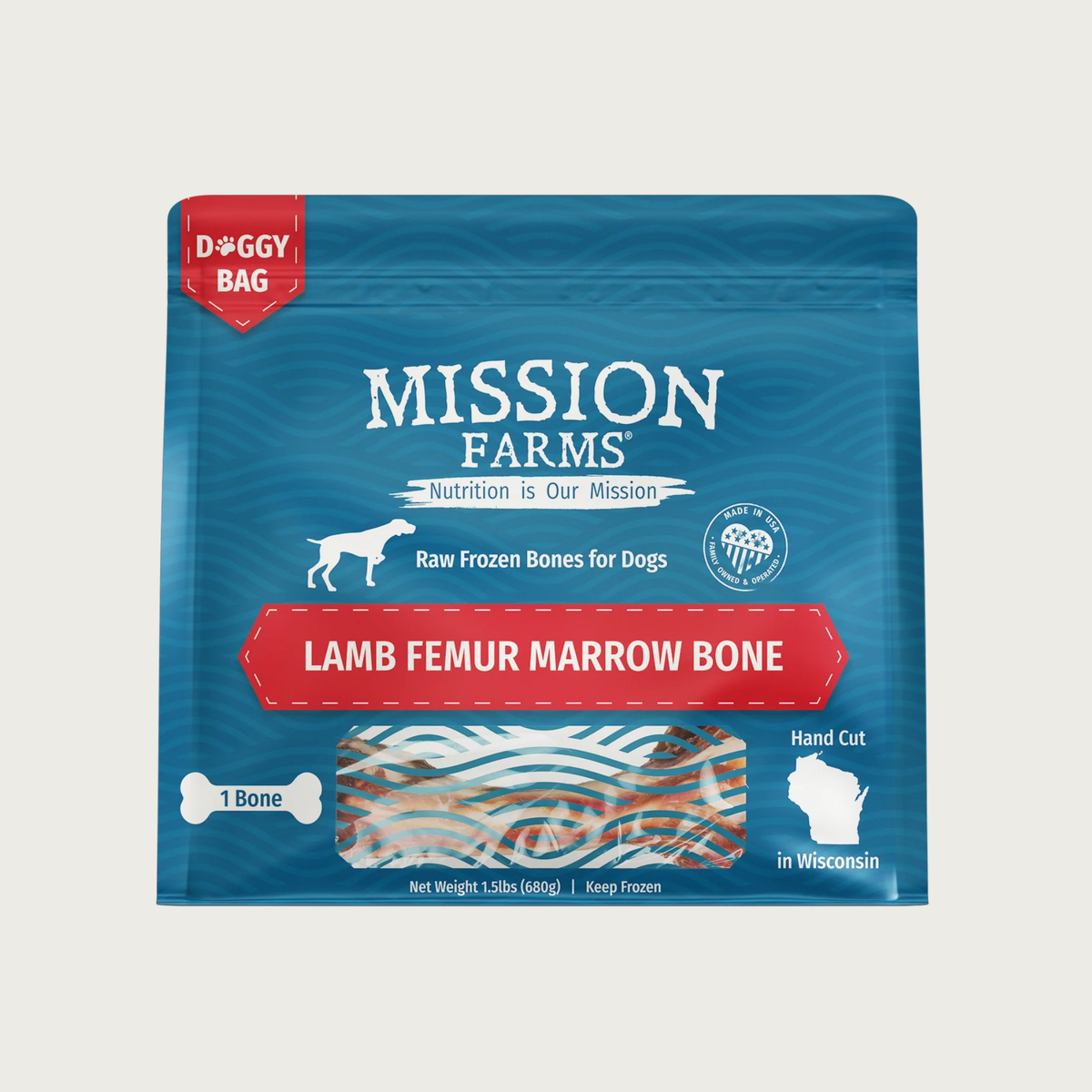 Blue bag with red accents, of Mission Farms, Raw Frozen Bones for Dogs; Lamb Femur Marrow Bone. Small transparent window shows the bone inside. 1 bone, hand cut in Wisconsin. Net wt. 1.5 lbs.