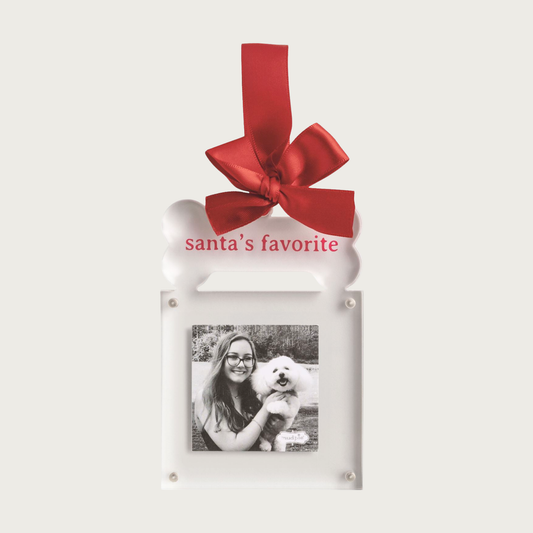 Christmas-themed, decorative white ornament with square shaped photo frame, with large dog bone above it. On the dog bone, text reads 'Santa's Favorite' in red. Hangs from a red ribbon.