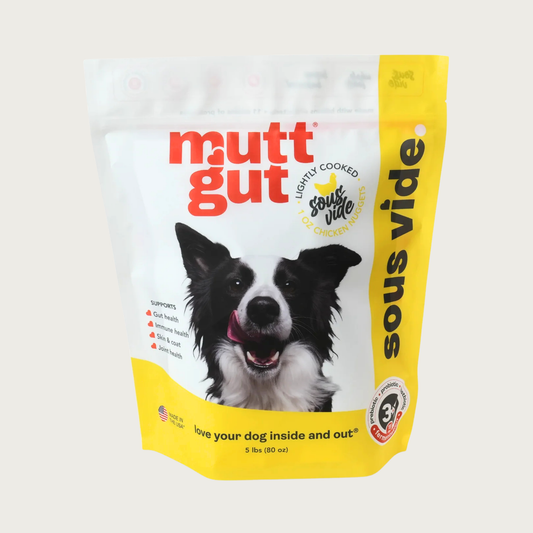 A 5 lb bag of Mutt Gut sous vide lightly cooked chicken dog food, featuring a white and yellow stand-up, resealable bag with a picture of a Border Collie on the front. 1 oz nuggets.