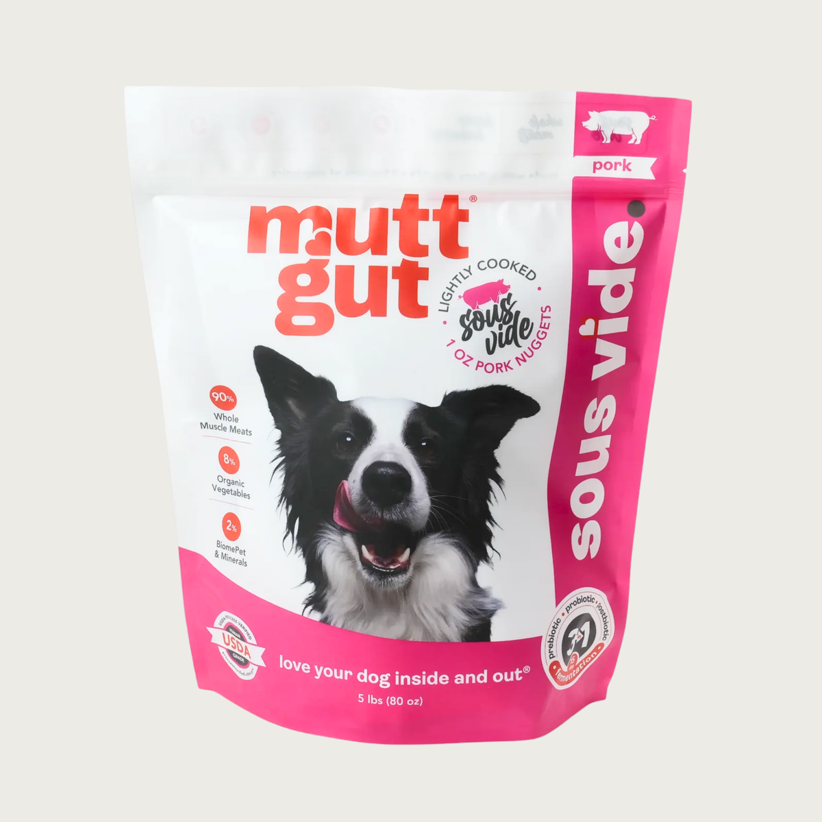A 5 lb bag of Mutt Gut sous vide lightly cooked pork dog food, featuring a white and hot pink stand-up, resealable bag with a picture of a Border Collie on the front. 1 oz nuggets.