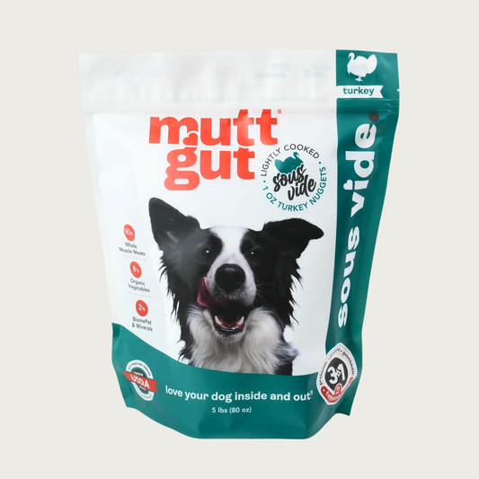 A 5 lb bag of Mutt Gut sous vide lightly cooked turkey dog food, featuring a white and teal stand-up, resealable bag with a picture of a Border Collie on the front. 1 oz nuggets.