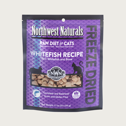An 11 ounce purple bag of Northwest Naturals freeze-dried raw diet for cats, whitefish recipe. Clear window on bag shows small bite-sized nibbles.