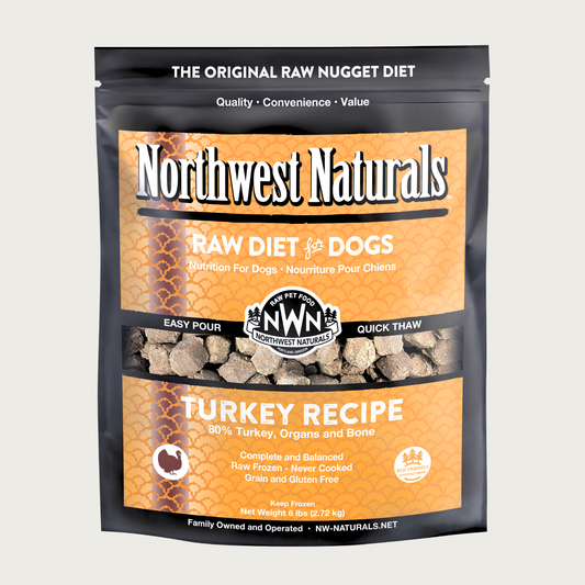 A 6 pound yellow-orange bag of Northwest Naturals frozen raw diet for dogs, turkey recipe. Clear window on bag shows small cube-sized nuggets.