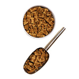 A scoop and bowl full of Open Farm's Air Dried dog food. Pieces are small, brown, and jerky-like.