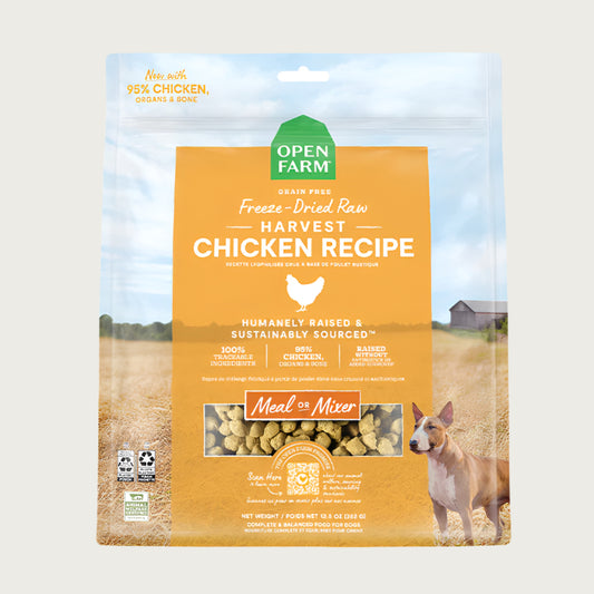 A 13.5 oz bag of Grain Free, Open Farm Freeze-Dried-Raw Harvest Chicken Recipe dog food. Meal or Mixer, Humanely raised and sustainably sourced. A photo of a Bull Terrier dog standing in a field on a farm covers the bag, with a yellow bar in the center to highlight the white text over it.
