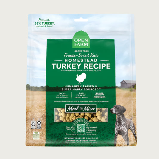 A 13.5 oz bag of Grain Free, Open Farm Freeze-Dried-Raw Homestead Turkey Recipe dog food. Meal or Mixer, Humanely raised and sustainably sourced. A photo of a Pointer dog standing in a field on a farm covers the bag, with a green bar in the center to highlight the white text over it.