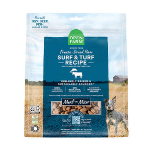A 13.5 oz bag of Grain Free, Open Farm Freeze-Dried-Raw Surf & Turf Recipe dog food. Meal or Mixer, Humanely raised and sustainably sourced. A photo of a Cattle Dog standing in a field on a farm covers the bag, with a blue bar in the center to highlight the white text over it.
