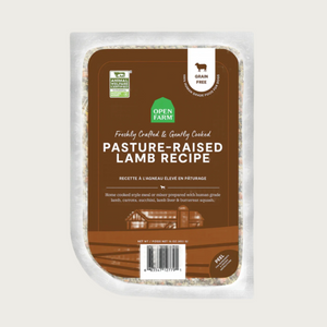 A 16 oz clear pouch of Open Farm Freshly Crafted & Gently Cooked Pasture-Raised Lamb Recipe. Brown label covers the front, with product details: Grain Free, 100% Human Grade Food for Dogs, Animal Welfare Certified. Peel corner to open pouch.