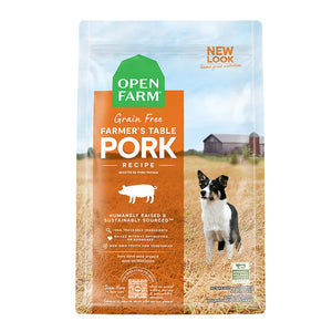A bag of Open Farm Grain Free Pork Recipe dog food. Humanely raised and sustainably sourced. A photo of a Border Collie dog standing in a field on a farm covers the bag, with an orange bar behind the white text to highlight it.