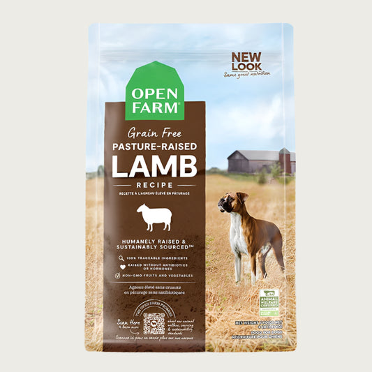 A bag of Open Farm Grain Free Lamb Recipe dog food. Humanely raised and sustainably sourced. A photo of a Boxer dog standing in a field on a farm covers the bag, with a brown bar behind the white text to highlight it.