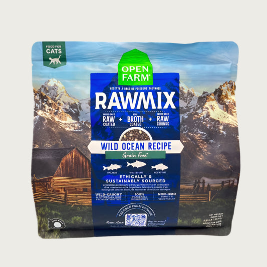 A 2.25 lb bag of Open Farm RawMix Grain Free Wild Ocean Recipe cat food. Ethically and sustainably sourced. A mountain ranch scene is in the background of the bag, with a vertical blue bar behind the white text to highlight it.