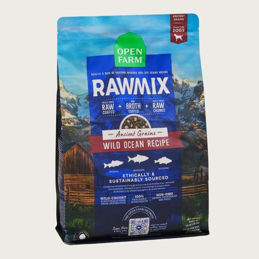 A bag of Open Farm RawMix Ancient Grains Wild Ocean Recipe dog food. Ethically and sustainably sourced. A mountain ranch scene is in the background of the bag, with a vertical blue bar behind the white text to highlight it.