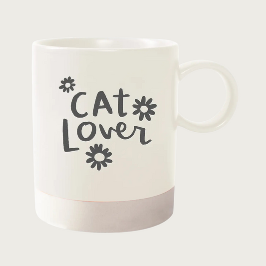 Cream mug with darker cream colored base. Text in center reads 'Cat Lover' in charcoal gray script font with 3 charcoal gray daisies around text. 