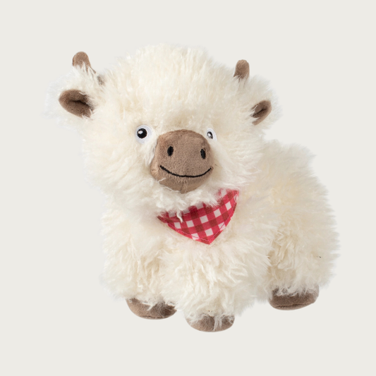 Plush cow dog toy with cream colored faux fur, taupe horns, ears, snout, and feet, wearing a red & white checkered bandana. Sweet embroidered facial details.