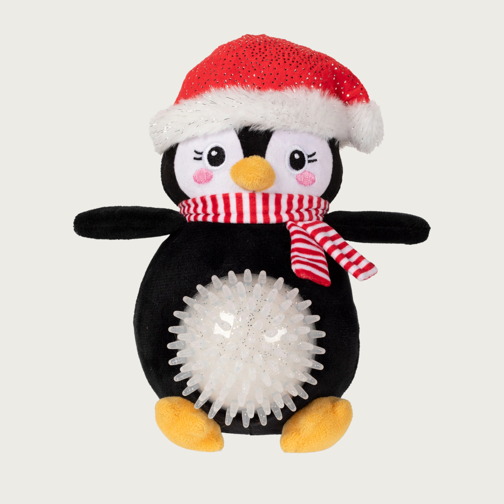 Plush full body penguin dog toy wearing a Santa hat and red & white scarf. Its belly is a white, glittery & spiky rubber ball that sticks out.