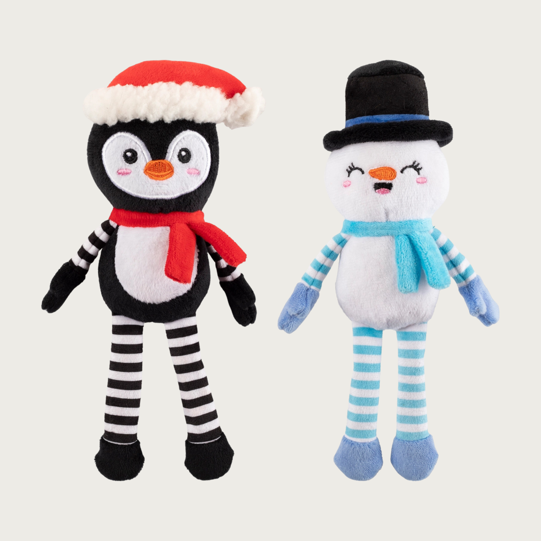 Full body, plush penguin & snowman dog toys, side by side. Penguin is wearing a Santa hat & red scarf, has a black & white body, and black & white striped arms & legs. The snowman is wearing a black top hat & light blue scarf, and has a white body with light blue & white striped arms & legs.