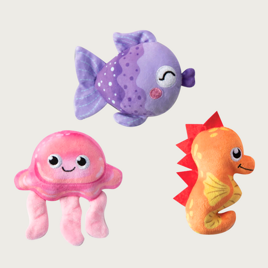 Three plush dog toys shaped like a purple fish, pink jellyfish, and orange seahorse. Each features cute, embroidered facial details, and muli-hued shading.