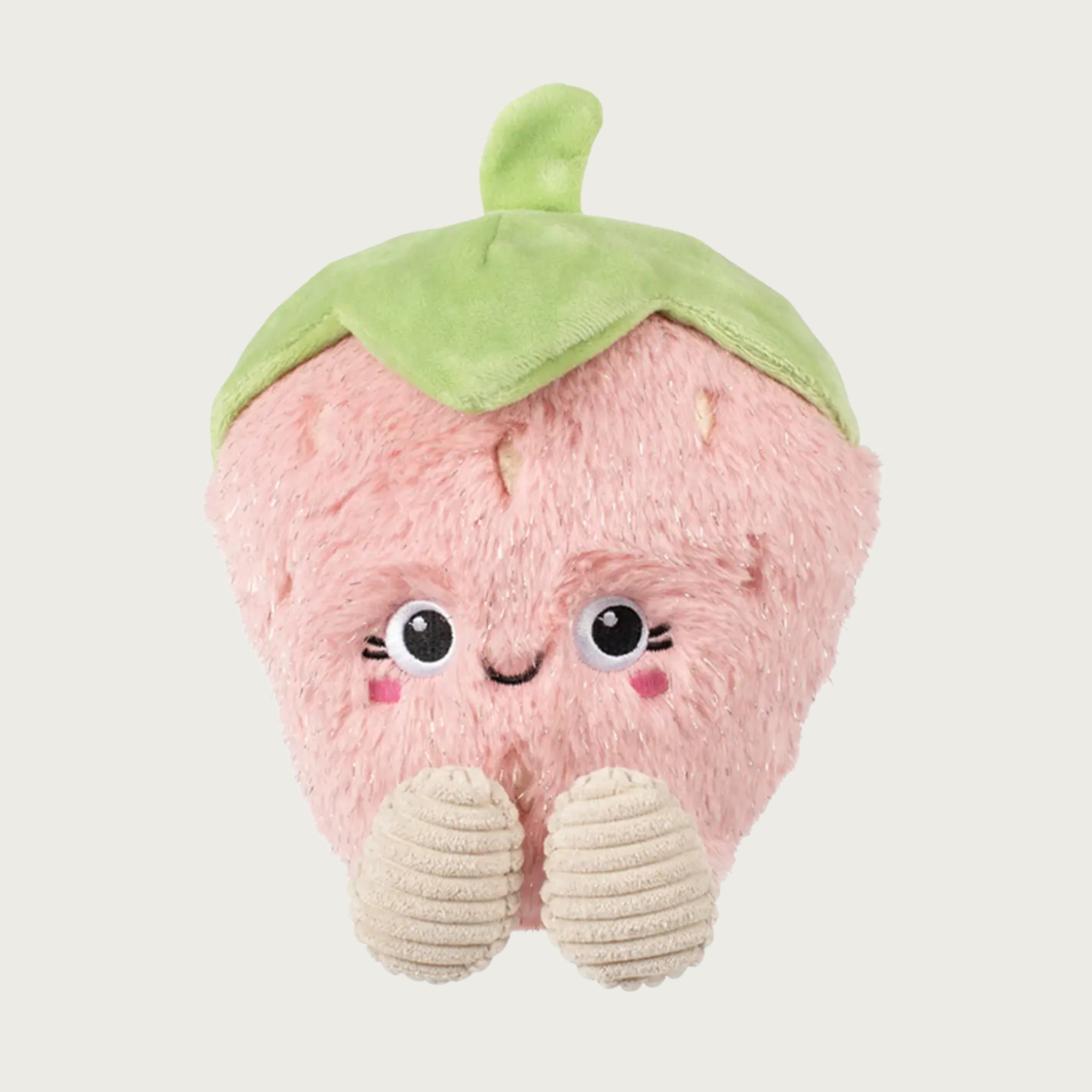 Plush, pale pink strawberry dog toy. It has a pale green stem & leaf on its head, and cream corduroy feet. Sweet embroidered facial expression.