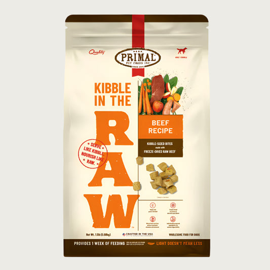 A 1.5 pound bag of beef recipe Kibble in the Raw dog food from Primal Pet Foods. Text on bag reads "Kibble sized bites made with freeze-dried raw beef" and "Serve like kibble. Nourish like raw." There is an image of fresh produce and a piece of raw steak, and a smaller image of the bite-sized morsels that are in the bag.