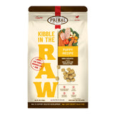 A 9 pound bag of puppy recipe Kibble in the Raw dog food from Primal Pet Foods. Text on bag reads "Kibble sized bites made with freeze-dried raw chicken & pork" and "Serve like kibble. Nourish like raw." There is an image of fresh produce with a raw chicken breast and pork chop, and a smaller image of the bite-sized morsels that are in the bag.
