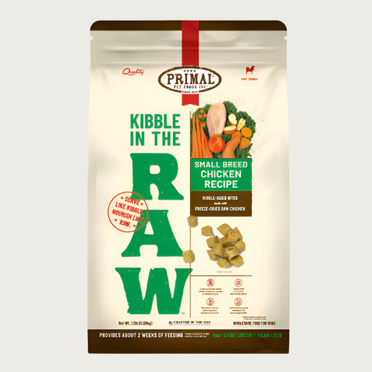 A 1.5 pound bag of small breed chicken recipe Kibble in the Raw dog food from Primal Pet Foods. Text on bag reads "Kibble sized bites made with freeze-dried raw chicken" and "Serve like kibble. Nourish like raw." There is an image of fresh produce with a raw chicken breast, and a smaller image of the bite-sized morsels that are in the bag.