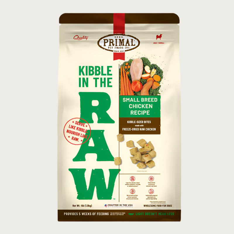 A 4 pound bag of small breed chicken recipe Kibble in the Raw dog food from Primal Pet Foods. Text on bag reads "Kibble sized bites made with freeze-dried raw chicken" and "Serve like kibble. Nourish like raw." There is an image of fresh produce with a raw chicken breast, and a smaller image of the bite-sized morsels that are in the bag.