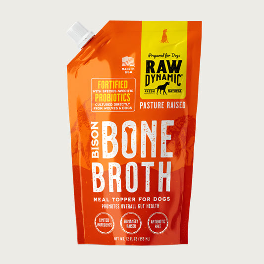 Raw Dynamic Bison Bone Broth for dogs in a 12 oz orange pouch, featuring pasture raised bison. Fortified with species-specific probiotics to promote overall gut health. Treat or meal topper for dogs.