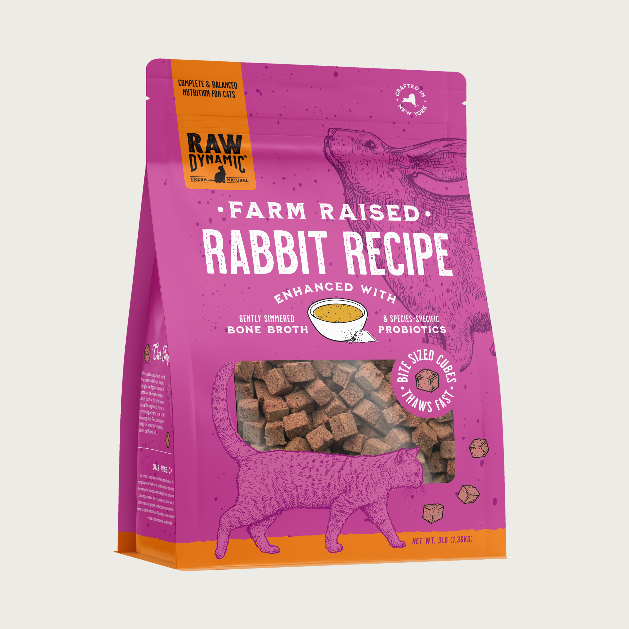 Raw Dynamic Farm Raised Rabbit frozen raw cat food in a pink bag. Enhanced with gently simmered bone broth & species-specific probiotics. Bite sized cubes - thaws fast. Clear window shows tiny cubes of reddish-brown food. Net wt. 3lbs.