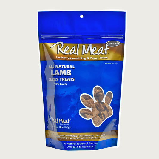 12 oz blue bag of all natural lamb jerky dog & puppy treats from The Real Meat Company. 95% lamb, no fillers. Small, clear, paw print shaped window on bag shows product inside - brown, rectangular shaped treats.