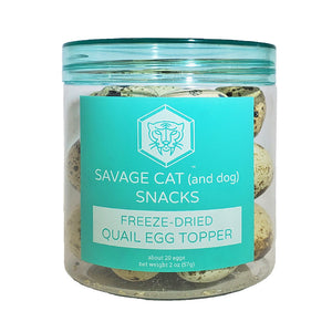 A 2 oz clear plastic container, filled with freeze-dried quail eggs by Savage Cat. Snacks for cats and dogs, about 20 eggs per container. Eggs are very small, and have a tan color with brown speckles.