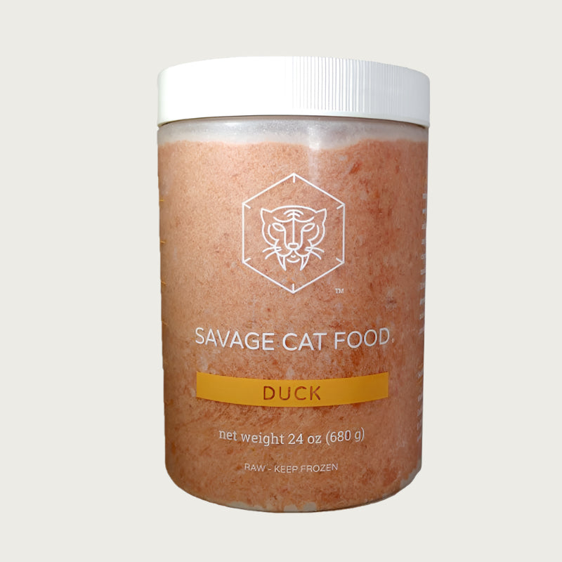 A 24 oz plastic tub of Savage Cat Food, Duck recipe for cats. Tub is clear, with light reddish brown food inside. Raw. Keep Frozen.