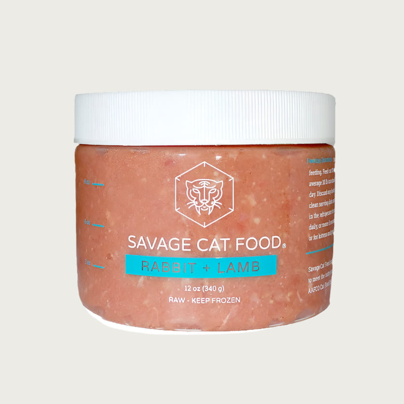 A 12 oz plastic tub of Savage Cat Food, Rabbit and Lamb recipe for cats. Tub is clear, with reddish food inside. Raw. Keep Frozen.