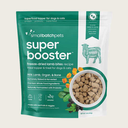 A dark green and white, 7 ounce bag of Smallbatch Super Booster freeze-dried raw lamb bites recipe for dogs and cats. Can be used as a meal topper or treat. The bag has a small, clear window showing bite-sized treat pieces, about 1/2" to 1" long.