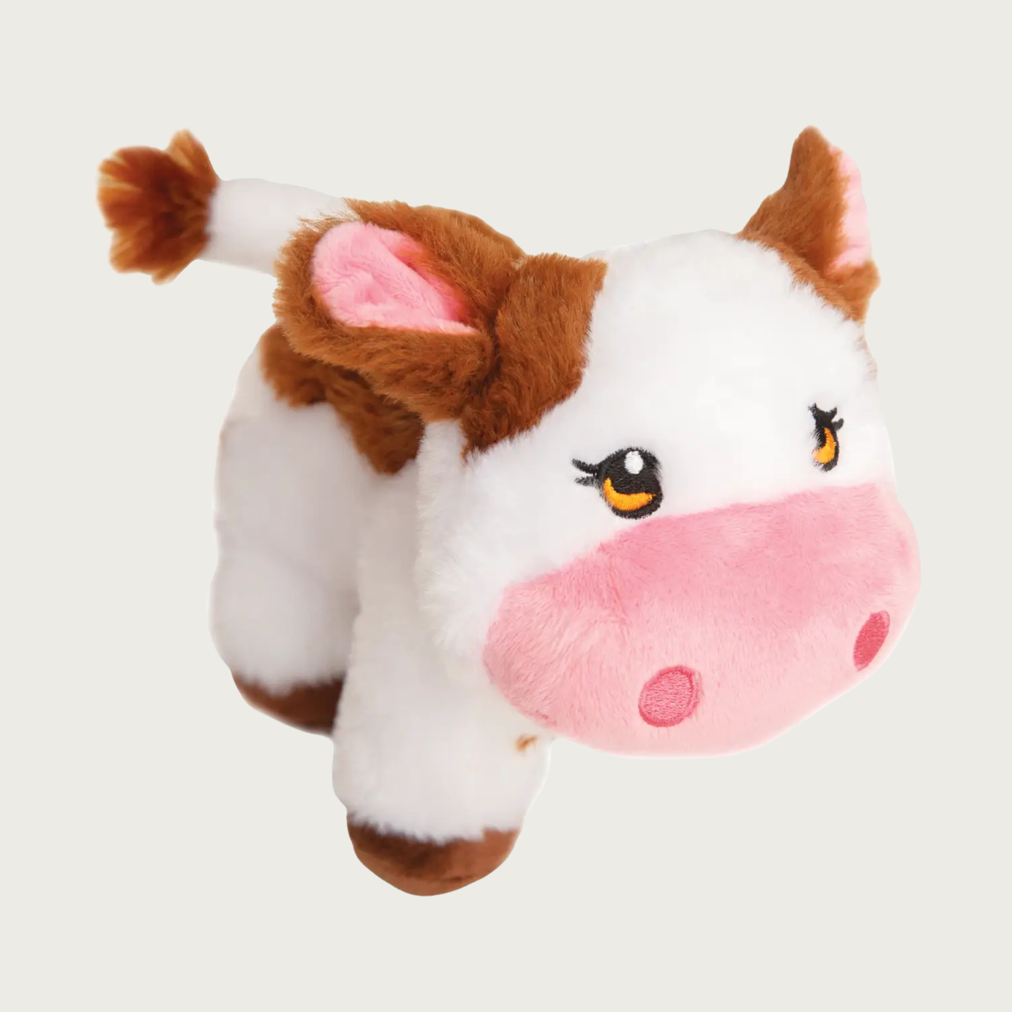 Plush dog toy shaped like a cow, with white body and medium brown spots. She has a pink snout & inner ears, and embroidered facial details.
