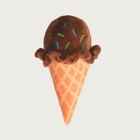 Plush dog toy in the shape of an ice cream cone. Body looks like a waffle cone, ice cream is dark brown with multicolored, embroidered sprinkles.